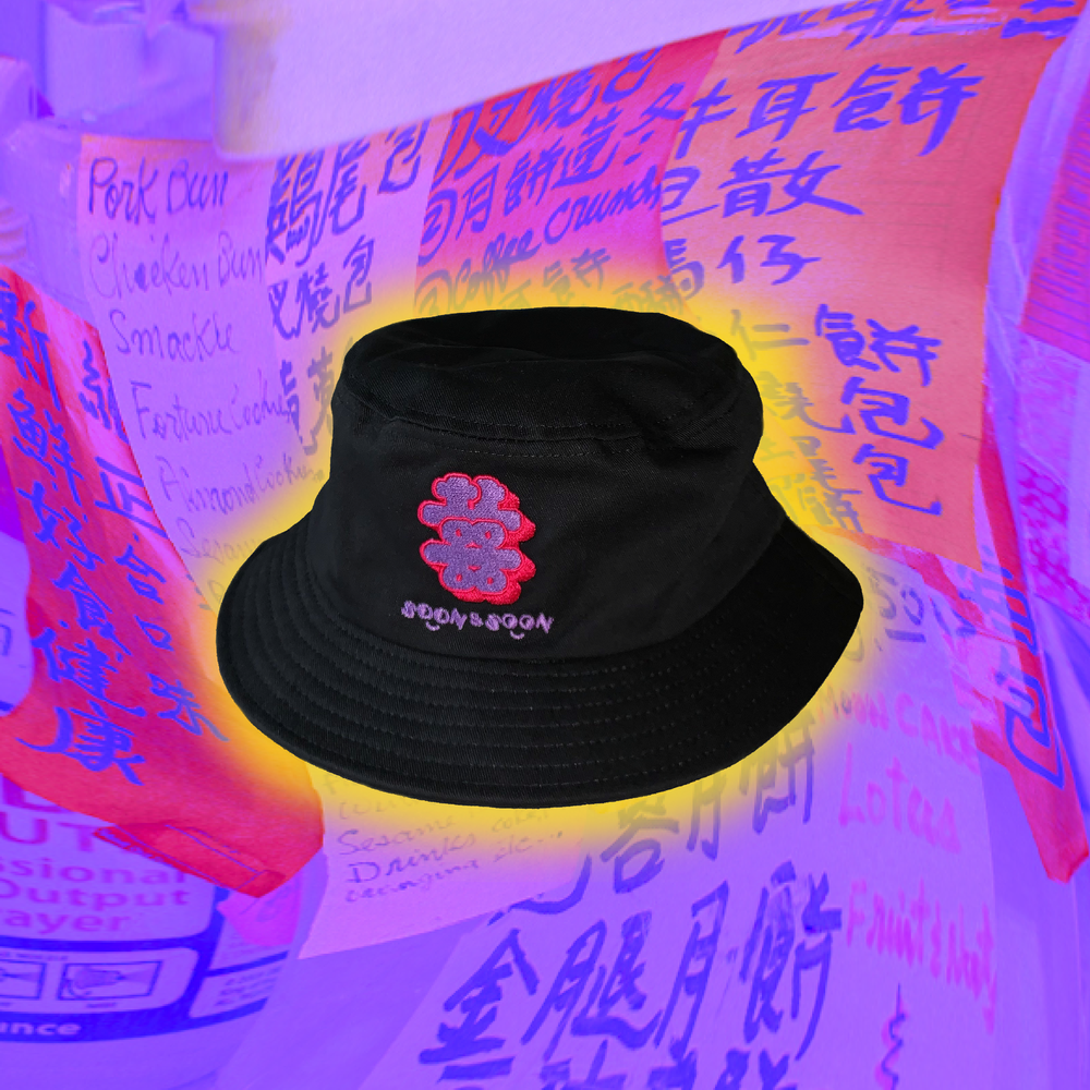 A black bucket, with Soon & Soon logo (Double Happiness) on the front. It's on a purple background.